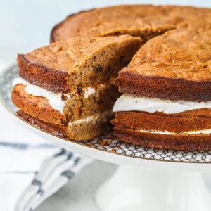 Angeschnittener veganer Karottenkuchen aus drei Böden mit zwei Schichten Kokoscreme